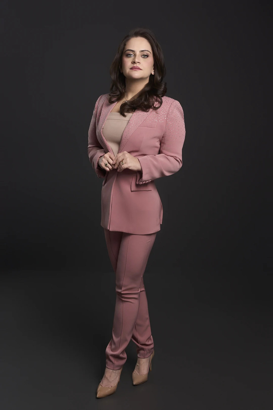 Dra. Claryssa Nascimento em traje rosa, retrato de estúdio de corpo inteiro