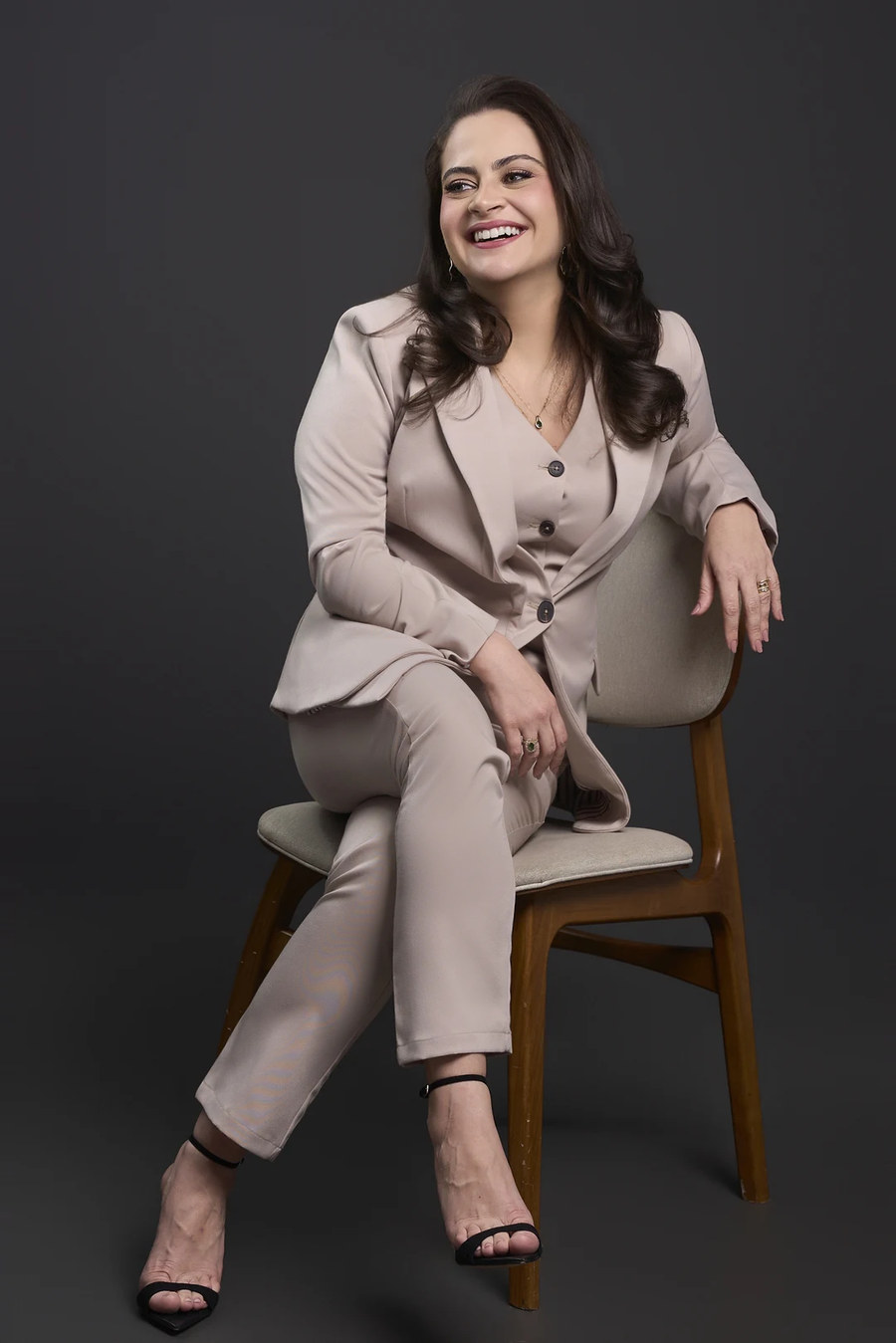Dra. Claryssa Nascimento sentada, sorrindo, retrato de estúdio